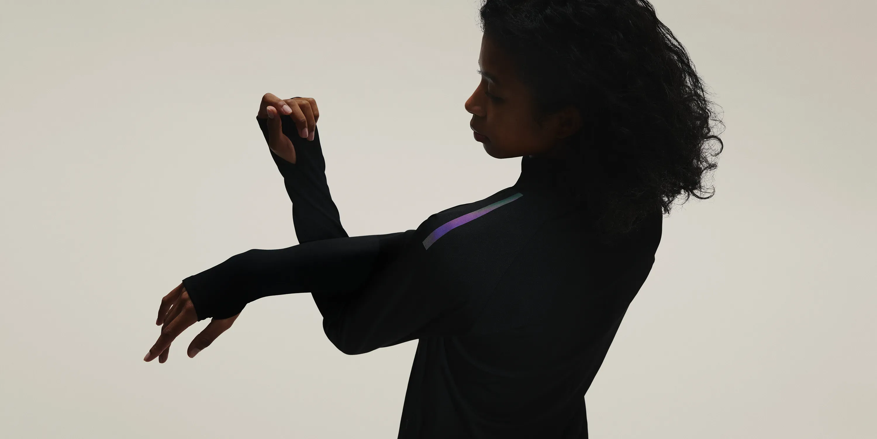 ストレッチをする女性の上半身シルエット。肩のリフレクターが光っている。SOLAR-PERFORMANCE WEARの世界観を表現。